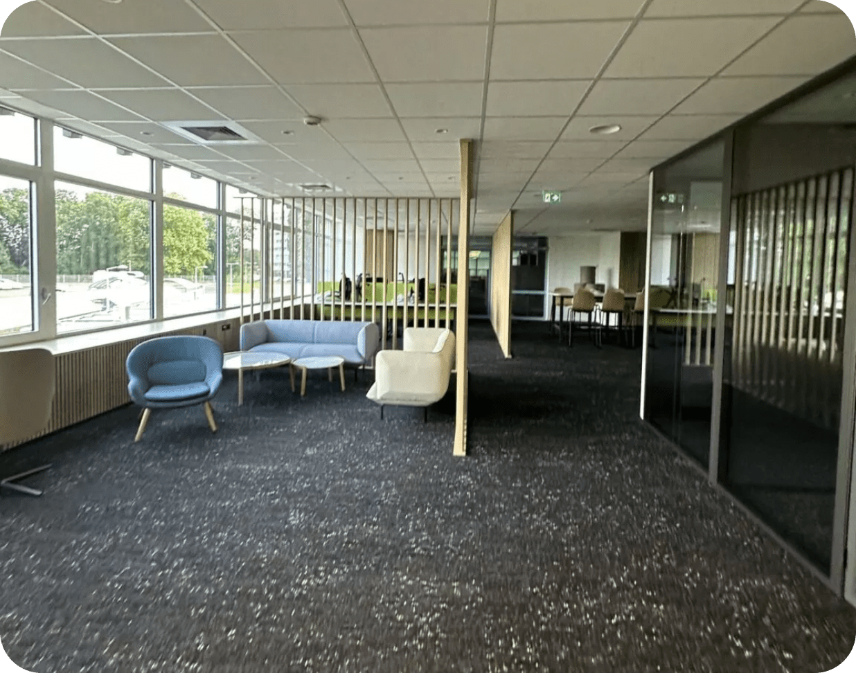 Locaux de bureau propre, réalisé par la société de nettoyage Kapnet Propreté. Canapé et chaise bleues dans un grand hall.