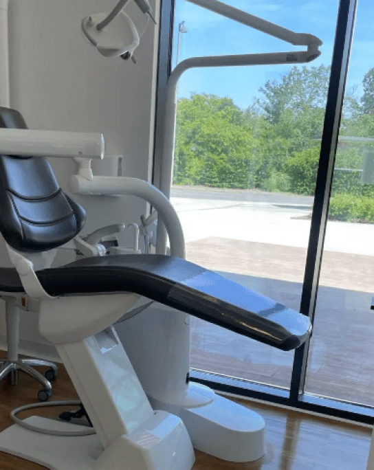 salle de cabinet dentaire avec une baie vitrée en fond. La salle de ce cabinet médical est propre.