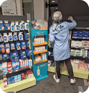 On voit une collaboratrice de chez Kapnet nettoyer une pharmacie.